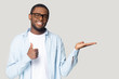 © fizkes - Attractive african guy showing open palm and thumbs up gesture