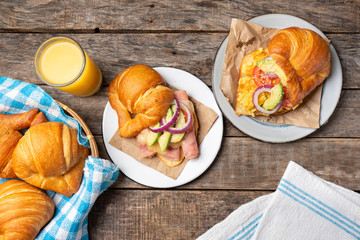 Wall Mural - Butter croissant breakfast with ham, cheese and scrambled eggs on wooden background