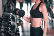 © Take Production - fitness ,workout, gym exercise ,lifestyle  and healthy concept. Women exercise by dumbbells at the indoor gym for good health at sunset in side view.