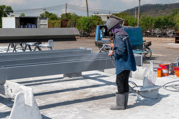 Wall Mural - The painter is working to painting color top coat on steel structure with spray gun, at industrial factory.