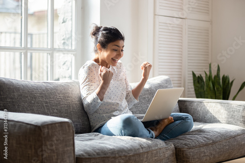 Fotografía Overjoyed ethnic girl get pleasant message on laptop