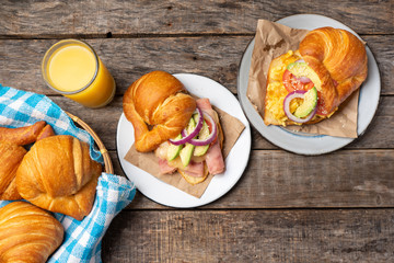 Wall Mural - Butter croissant breakfast with ham, cheese and scrambled eggs on wooden background