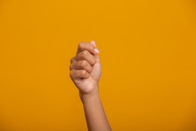 Woman Hand Holding Something On Yellow Background, Closeup Of Hand.