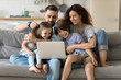 © fizkes - Family with kids spend time together using laptop websites