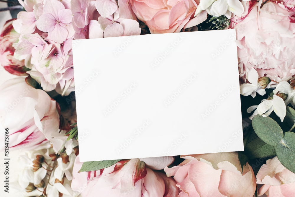 Wedding, birthday stationery mock-up scene. Blank paper greeting card, invitation. Decorative floral composition. Closeup of pink roses petals, peonies, hydrangea flowers and eucalyptus leaves. - obrazy, fototapety, plakaty 