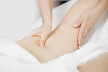 Anti-cellulite massage treatment on legs of young women beauty spa