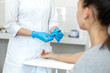 © Kate - a gloved nurse removes a sterile needle from its packaging in front of the patient. Blood sampling procedure.