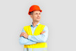 © Viktoriia - Construction. Mature man in hardhat and uniform standing isolated on white crossed arms looking aside dreamful