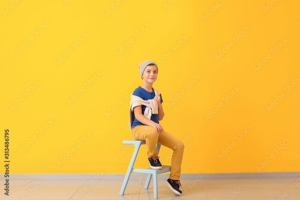 Cute fashionable boy on color background