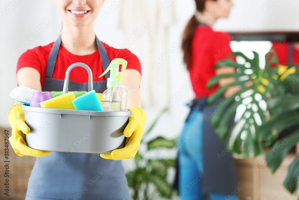Janitor with cleaning supplies in bathroom