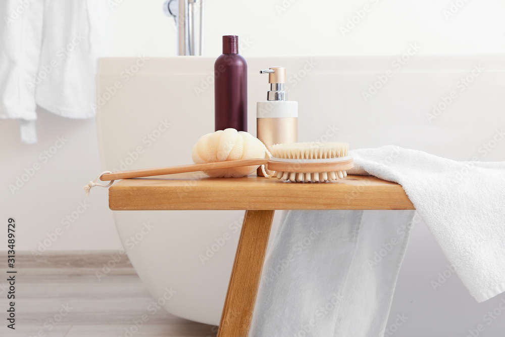 Body care cosmetics with accessories on bench in bathroom