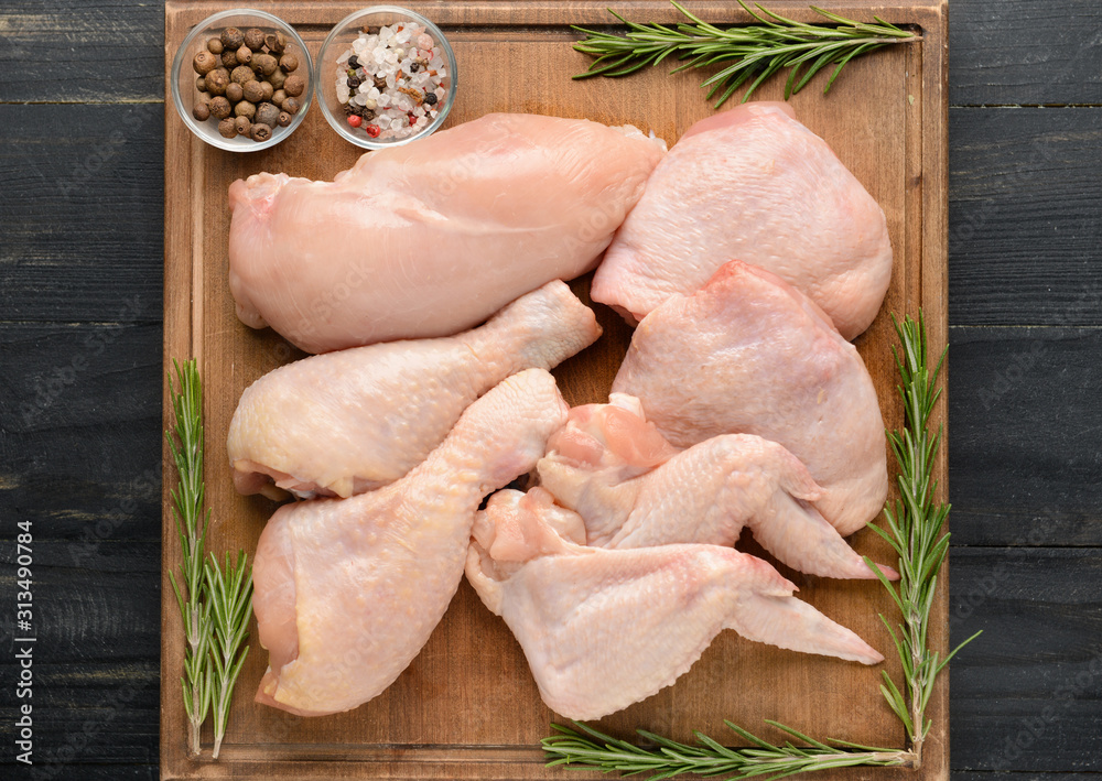 Board with raw chicken meat on wooden background