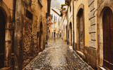Fototapeta Uliczki - Old street whit ancient building and stone paved road in Rome city center, Italy.