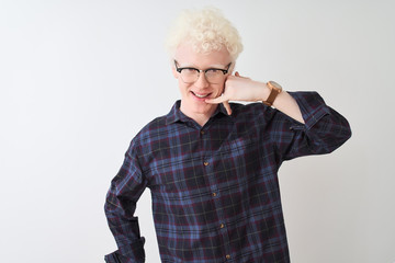 Wall Mural - Young albino blond man wearing casual shirt and glasses over isolated white background smiling doing phone gesture with hand and fingers like talking on the telephone. Communicating concepts.