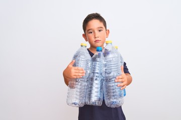 Poster - Beautiful kid boy recycling plastic bottles standing over isolated white background with a confident expression on smart face thinking serious