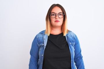 Poster - Young beautiful woman wearing denim shirt and glasses over isolated white background with serious expression on face. Simple and natural looking at the camera.