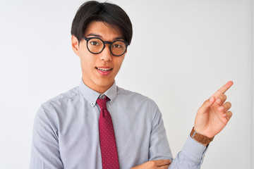 Wall Mural - Chinese businessman wearing tie and glasses standing over isolated white background very happy pointing with hand and finger to the side