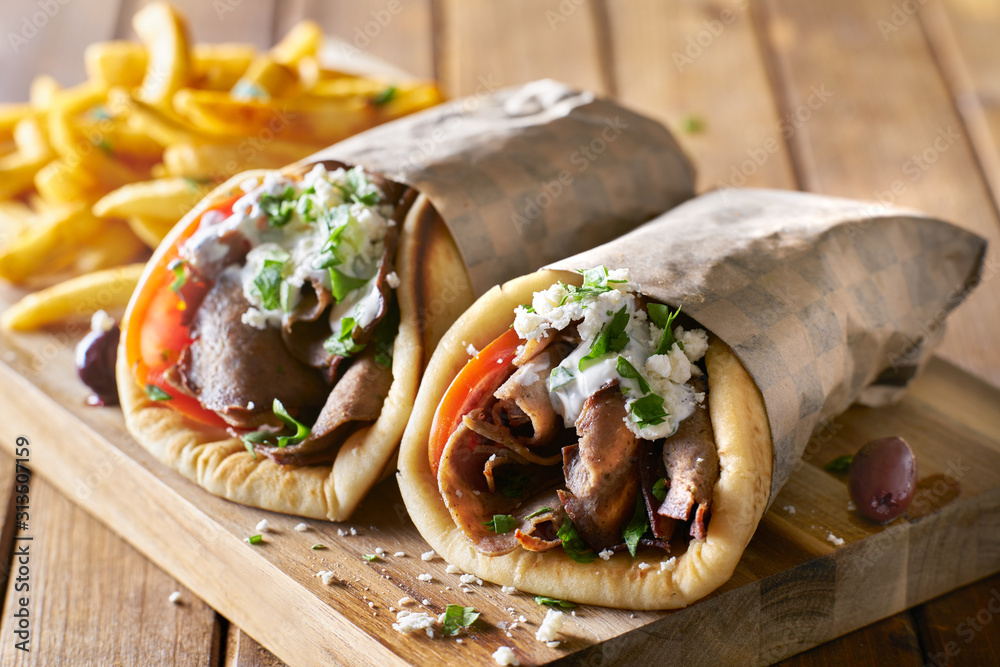 two greek gyros with shaved lamb and french fries - obrazy, fototapety, plakaty 