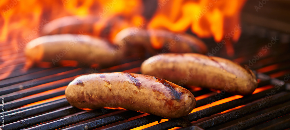 brats cooking over flaming barbecue grill - obrazy, fototapety, plakaty 