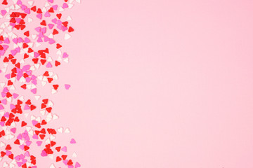 Poster - Valentines Day side border with candy heart sprinkles over a pink textured background. Copy space.