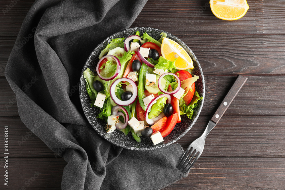 Plate of tasty Greek salad on table
