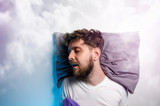Fototapeta  - Man sound asleep , enjoying his nap, graphic clouds added , dreaming 
