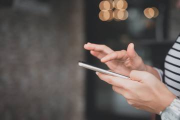 Woman hand using smart phone at coffee shop. Technology business concept.