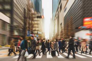 blurred crowd of unrecognizable business people walking on zebra crossing in rush hour working day, 