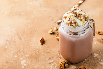 Wall Mural - Winter hot dark chocolate with whipped cream and crushed walnuts in glass jar, copy space