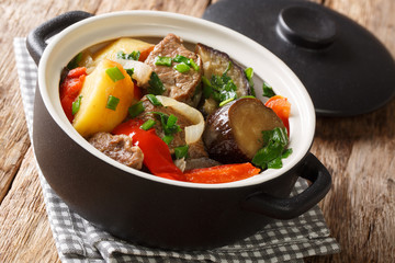  Chanakhi is a traditional Georgian dish of lamb stew with tomatoes, aubergines, potatoes, greens and garlic close-up. Horizontal