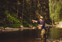 A Fly Fisherman Fishing For Trout On The Mountain River In Northern Idaho.
