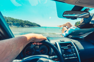 Wall Mural - first person view man sitting in car woman laying at hood