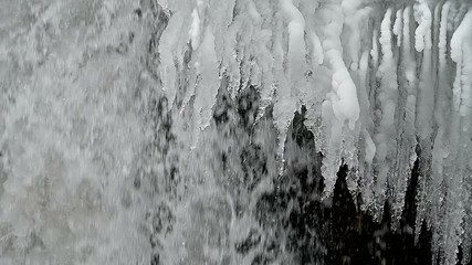 Wall Mural - frozen waterfall on a rock in the mountains. water flows from a frozen tonel.