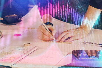 Double exposure of man writing on paper with forex graph.