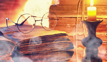 Wall Mural - Vintage glasses on an old retro book on a background of the moon. Reading a book by candlelight. The concept of book thrillers and novels.