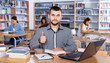 © JackF - Portrait of happy confident male student working with laptop and book in public library