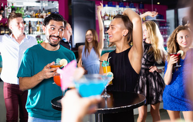 Wall Mural - Man with woman are drinking cocktails on corporate party.