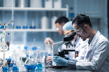 Wall Mural - young scientist looking through a microscope in a laboratory. young scientist doing some research.