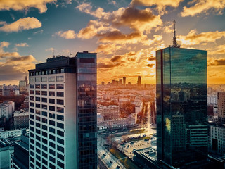 Wall Mural - Beautiful panoramic aerial drone view to the Сenter of modern Warsaw city with silhouettes of skyscrapers in in the rays of the setting winter January sun - amazing sunset, Poland