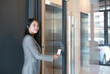 © zilvergolf - Door access control - young officer woman holding a key card to lock and unlock door for access entry.