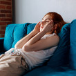 © Dmitrii Kotin - Young woman feels bad and suffering from headache at home.