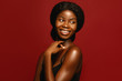 © Beauty Agent Studio - Beauty. African American beautiful woman portrait. Brunette curly haired young model with dark skin and perfect smile against red background