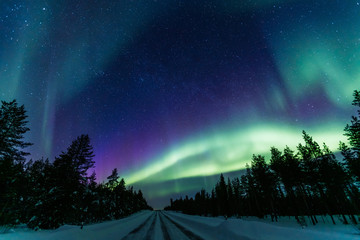 northern lights aurora borealis activity over the road in finland, lapland