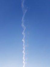 Inversion Trail Of An Airplane In The Blue Sky