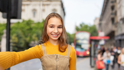 Sticker - people concept - happy smiling young teenage girl taking selfie over london city street background