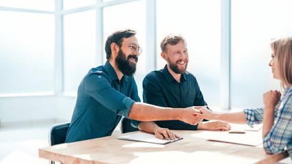 employer shaking hands with a new employee of the company.