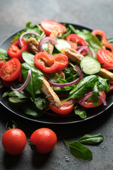 Wall Mural - Fresh vegetable salad with chicken meat, herbs and olive oil in a dark plate on a dark background. Healthy food.