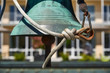 Seil hängt verknotet an einer kupfernen Glocke vor einem Seminarhaus