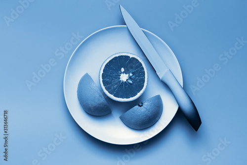 classic-blue-orange-citrus-fruit-cut-on-plate-color-of-the-year-2020-toned