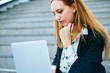© Westend61 - Young businesswoman sitting on stairs using laptop